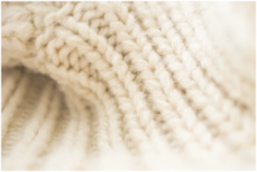 ベージュのニット生地の編み目を写したクローズアップ